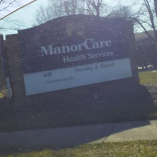 A sign for ManorCare Health Services in an outdoor setting.