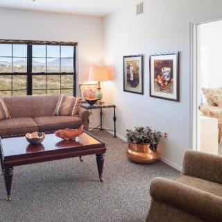 A cozy living room with a sofa, coffee table, and wall art.