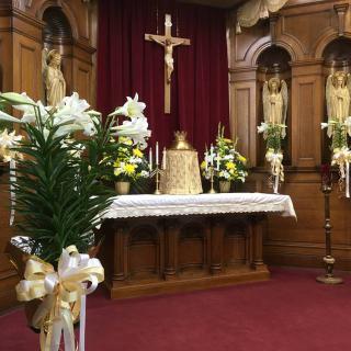 A church altar decorated with flowers and religious symbols.