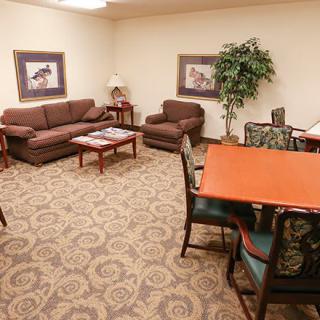 A cozy living room with brown couches, a coffee table, and a dining area.
