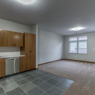 Modern unfurnished apartment with a kitchen and living area.