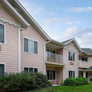 A suburban apartment building with balconies and landscaped surroundings.