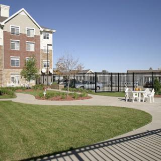 A peaceful outdoor space in an apartment complex featuring well-maintained gardens and seating areas.