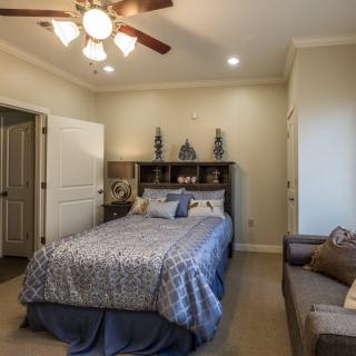 A cozy bedroom with a neatly made bed and stylish decor.
