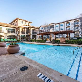 A modern residential complex with a refreshing outdoor swimming pool and patio area.