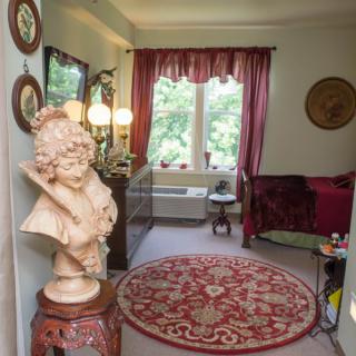 A cozy living room with classical decor, featuring a bust sculpture and elegant furnishings.