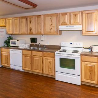 A spacious kitchen with wooden cabinets and modern appliances.