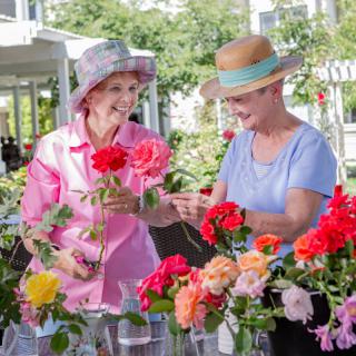 Two women enjoying a day of gardening and arranging flowers outdoors.