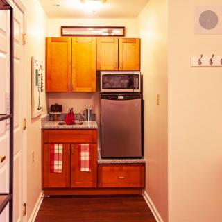 A compact kitchen area with wooden cabinets and modern appliances.