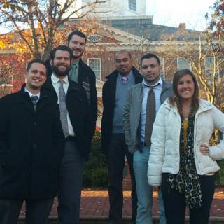 A group of people standing outside, smiling for the camera.
