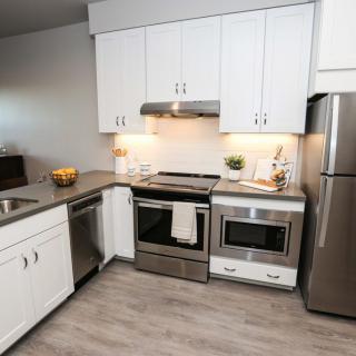 A modern kitchen with stainless steel appliances and white cabinets.