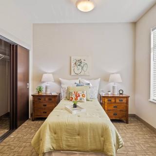 A cozy bedroom with a single bed, two wooden nightstands, and a closet.