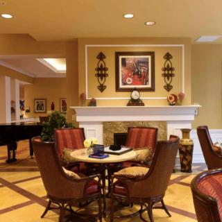 A cozy living room featuring a fireplace, a round table with chairs, and elegant decor.