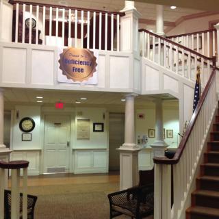 Hotel lobby with a reception desk and staircase.