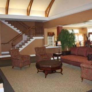 A spacious lobby with comfortable seating and a central staircase.