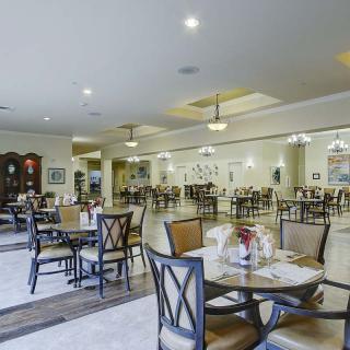 A spacious dining area with neatly arranged tables and chairs, featuring elegant interior design and lighting.