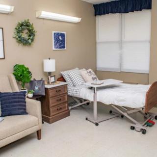 A well-decorated hospital room featuring a patient bed and comfortable seating.