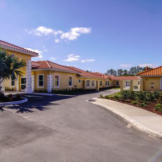 A view of residential buildings with a driveway under a clear blue sky.