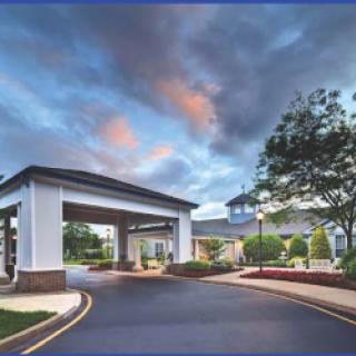 A welcoming entrance to a hospitality venue under a scenic evening sky.