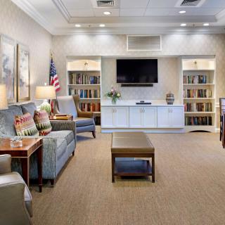A comfortable lounge area with seating, bookshelves, and a television.