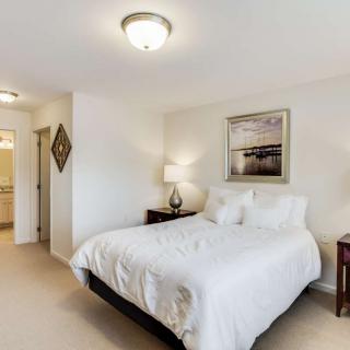 A cozy bedroom with a neatly made bed, bedside tables, and soft lighting.