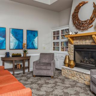 A modern living room featuring a cozy fireplace, vibrant artwork, and comfortable seating.