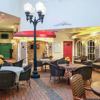A cozy indoor cafe setup with tables and chairs under decorative street lamps, creating a charming ambiance.