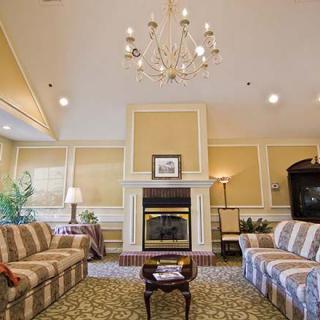 A cozy living room with sofas, a fireplace, and a chandelier.