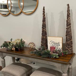 A festive holiday table setup with decorative trees, greenery, and a 'Merry Christmas' sign.