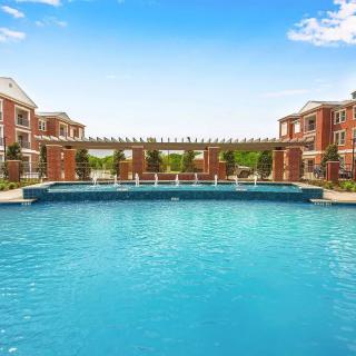 A luxurious outdoor swimming pool surrounded by elegant apartment buildings.