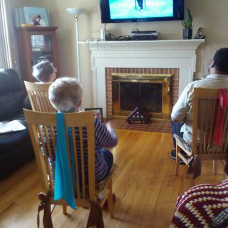 Three people watching television in a cozy living room setting.