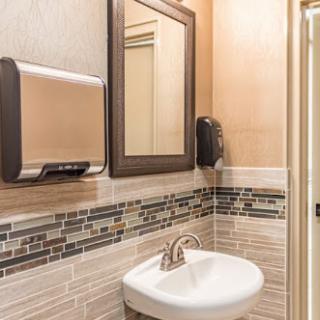 A well-designed bathroom featuring a modern sink, mirror, and hand dryer.