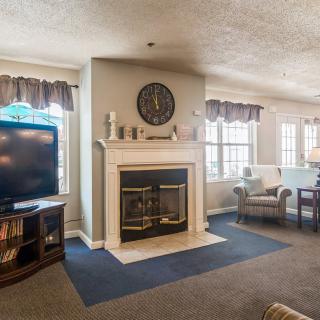 Cozy living room with a fireplace, television, and comfortable seating.