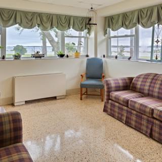 A cozy living room featuring plaid sofas and a gentle view through the windows.