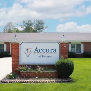 A nursing home with a sign reading 'Accura of Pomeroy' set on a well-maintained lawn.