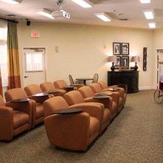 A cozy home theater room with leather recliners and a projector.