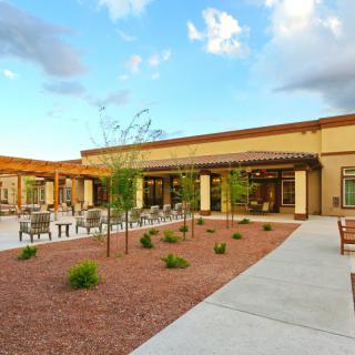 A spacious courtyard with seating and landscaped areas outside a modern building.