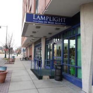 A storefront with a blue awning on a city street.