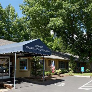 A building with a blue awning labeled 'Radiation Oncology Center', surrounded by trees and a parking lot.