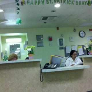 A reception area decorated for St. Patrick's Day with staff at work.