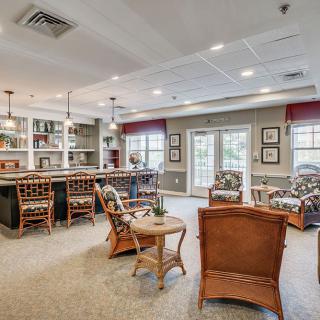 A cozy lounge area with a bar, comfortable seating, and warm lighting.
