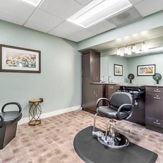 A well-organized hair salon station featuring a styling chair and a large mirror.