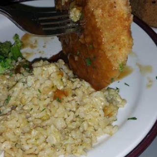 A delicious plate featuring a breaded item alongside fluffy rice and steamed broccoli.