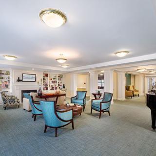 A spacious living room with elegant seating and a piano.