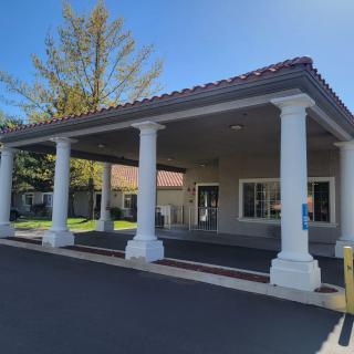 A building entrance with four white columns on a sunny day.