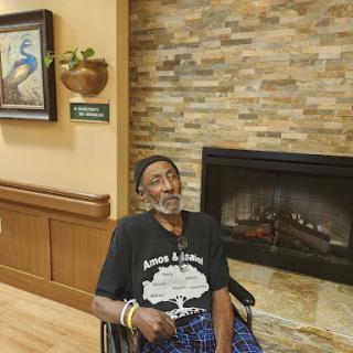 An elderly man enjoys a moment of relaxation in a cozy indoor setting.