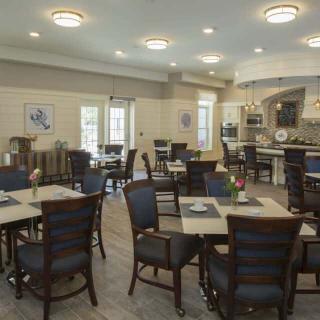 A modern and elegantly designed dining area with neatly arranged tables and chairs under soft lighting.