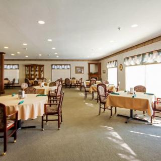 A well-lit dining area with neatly arranged tables and chairs.
