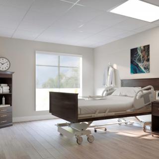 A bright and modern hospital patient room with a bed and large window.