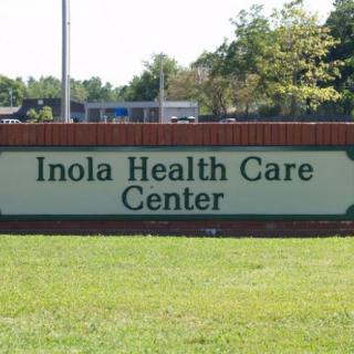 Sign for Inola Health Care Center in an outdoor setting.